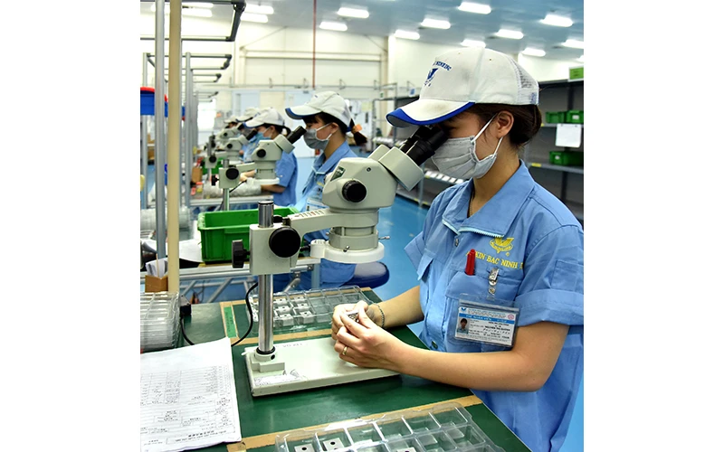Công nhân làm việc trong dây chuyền sản xuất linh kiện siêu chính xác tại Khu công nghiệp VSIP Bắc Ninh. Ảnh: ĐĂNG KHOA