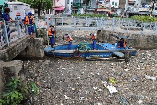 Công nhân công ty Môi trường Đô thị TP Hồ Chí Minh vớt rác và xác cá chết trên kênh Nhiêu Lộc - Thị Nghè. 