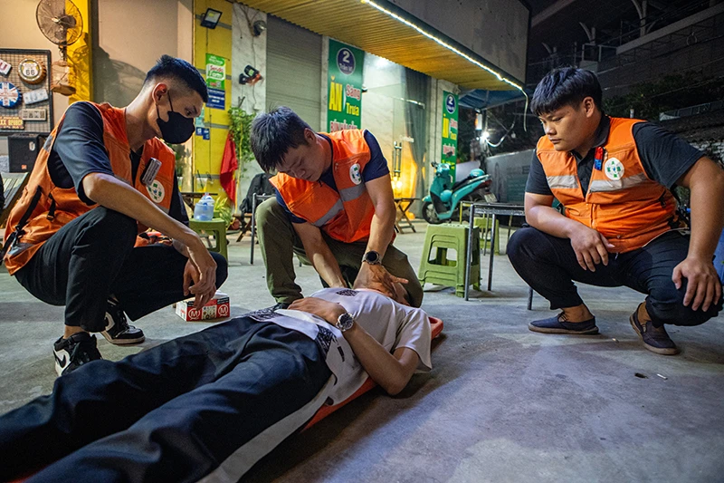  Anh Việt (ở giữa) hỗ trợ sơ cứu cho người bị nạn. 
