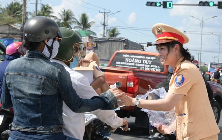 Cảnh sát giao thông (Công an Tiền Giang) tặng nước uống cho người dân. 