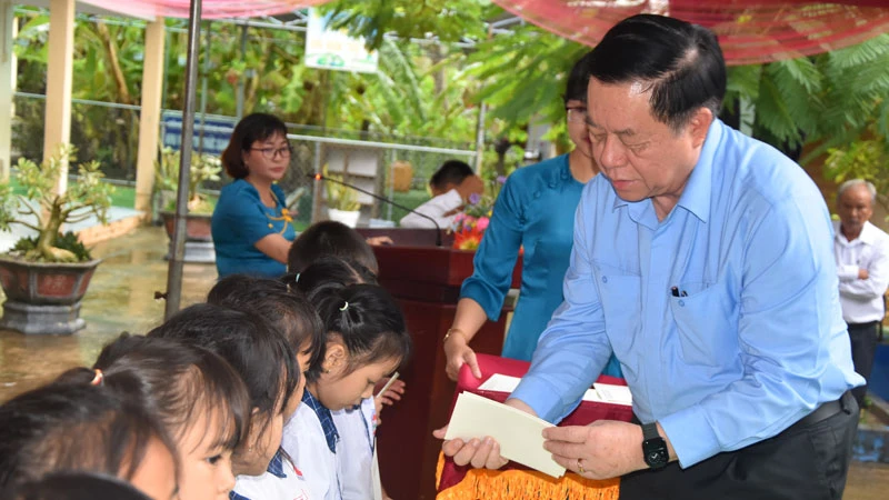 Đồng chí Nguyễn Trọng Nghĩa tặng học bổng cho học sinh nghèo hiếu học tại Trường tiểu học Nguyễn Thị Tốt.