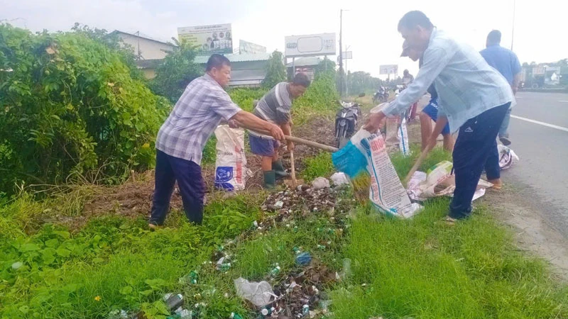 Nhân công thu gom vỏ chai bia bị bể để xử lý đúng nơi quy định.