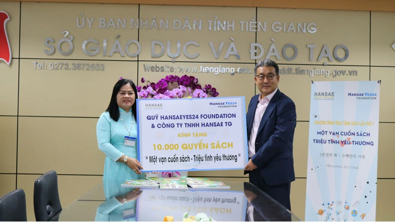 Ông Shin Soo-chul, Chủ tịch Công ty Hansae Việt Nam trao bảng tượng trưng cho đại diện ngành giáo dục và đào tạo tỉnh Tiền Giang.