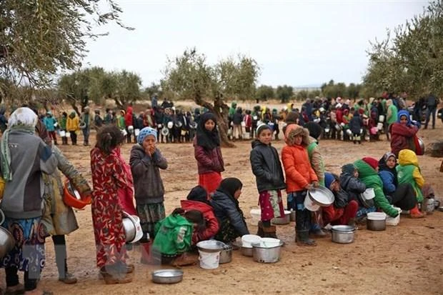Trẻ em Syria chờ nhận bữa ăn từ thiện tại một trại tị nạn ở làng Yazi Bagh, tỉnh Aleppo, Syria. (Ảnh: AFP/TTXVN)