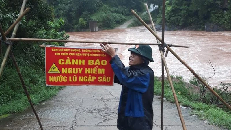 Bộ đội biên phòng đặt biển cảnh báo khu vực ngập sâu nguy hiểm ở vùng miền núi huyện Minh Hóa.
