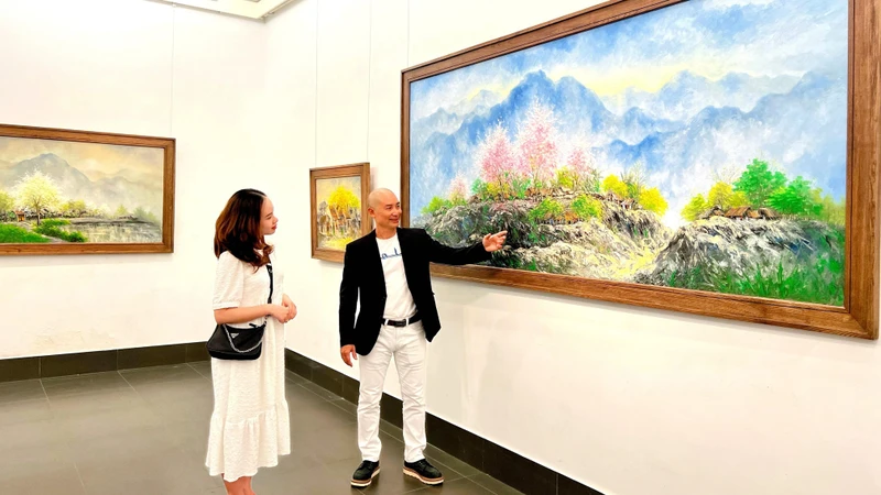 Họa sĩ Nguyễn Minh Sơn giới thiệu tác phẩm của mình tới khách tham quan.