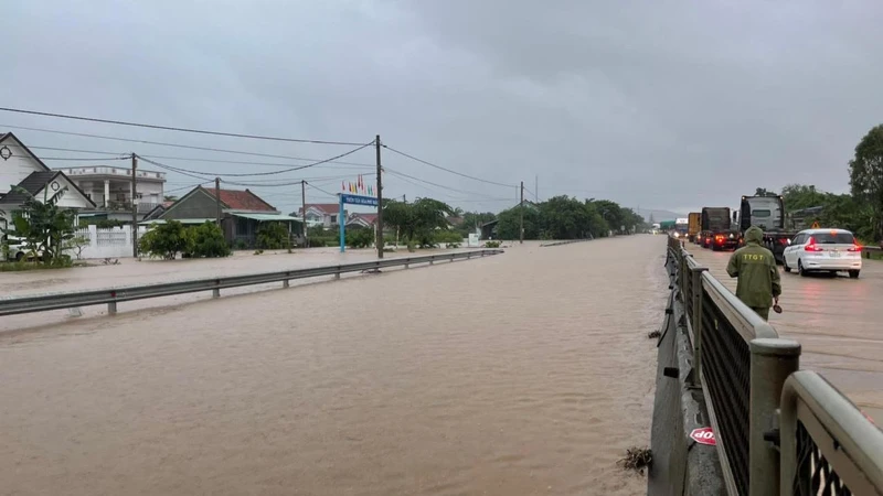 Nước ngập trên tuyến quốc lộ 1 đoạn qua xã an Mỹ, huyện Tuy An (Km1315), lực lượng chức năng điều tiết giao thông bảo đảm an toàn các phương tiện.