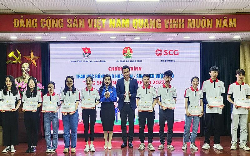 Đồng chí Nguyễn Phạm Duy Trang (thứ sáu từ trái sang) trao học bổng tặng một số đại diện sinh viên có hoàn cảnh khó khăn tại chương trình.