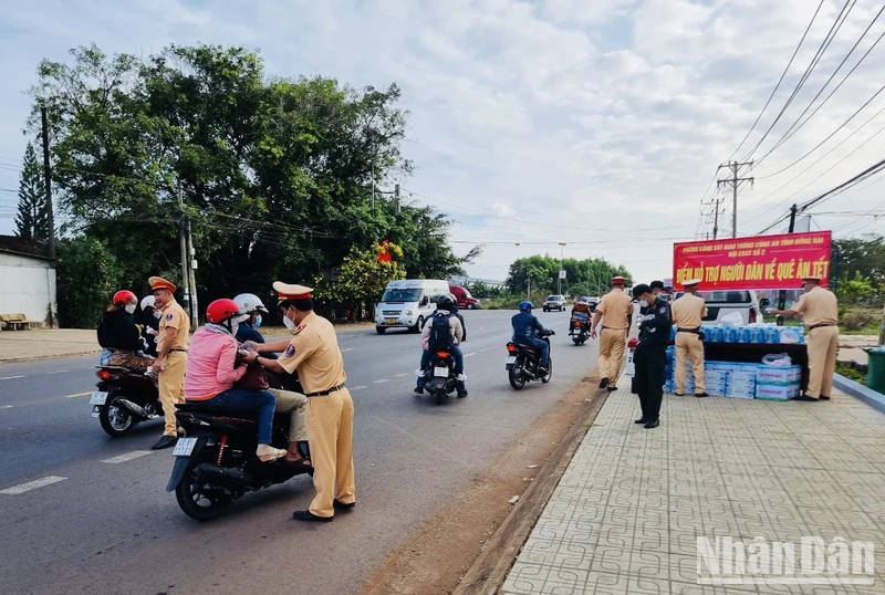 Lực lượng Cảnh sát giao thông Công an tỉnh Đồng Nai phát nước suối, khăn lạnh cho người dân về quê đón Tết trên quốc lộ 20.