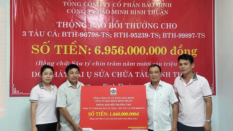 Ông Lê Minh Thép (đứng thứ 2 từ bên phải sang) chủ tàu cá BTh-96789-TS nhận thông báo bồi thường tại trụ sở công ty Bảo Minh Bình Thuận.