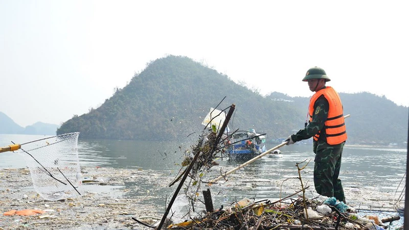 Thu gom rác tại khu vực vùng lõi Di sản Vịnh Hạ Long sau bão số 3. (Ảnh: TTXVN)