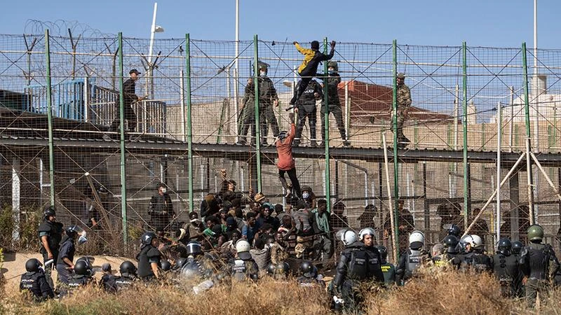 Người di cư cố gắng vượt biên giới từ Maroc vào vùng Melilla của Tây Ban Nha. (Ảnh AP) 