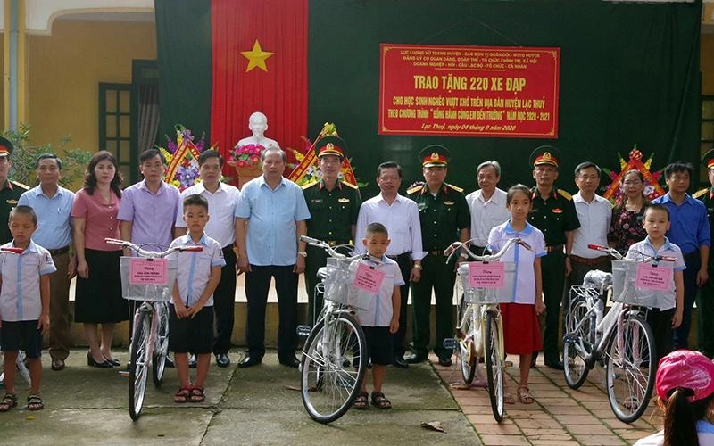 Ðại diện Bộ Chỉ huy quân sự tỉnh Hòa Bình cùng chính quyền địa phương trao xe đạp tặng học sinh nghèo huyện Lạc Thủy. 