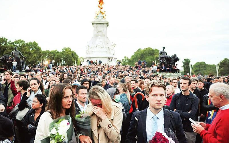 Người dân Anh tập trung bên ngoài Cung điện Buckingham để tưởng niệm Nữ hoàng. (Ảnh REUTERS) 