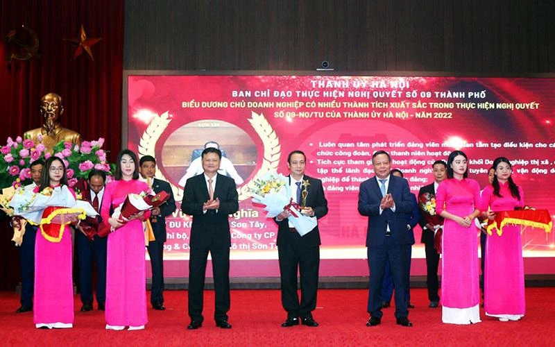 Lãnh đạo Thành ủy Hà Nội tặng hoa và biểu trưng cho các chủ doanh nghiệp có thành tích xuất sắc trong thực hiện Nghị quyết 09-NQ/TU. (Ảnh LƯƠNG TOÀN) 