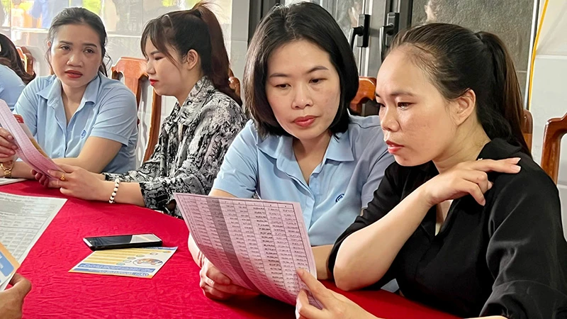 Cán bộ Bảo hiểm xã hội thị xã Ba Ðồn (Quảng Bình) tuyên truyền chính sách bảo hiểm xã hội tự nguyện cho người dân. 