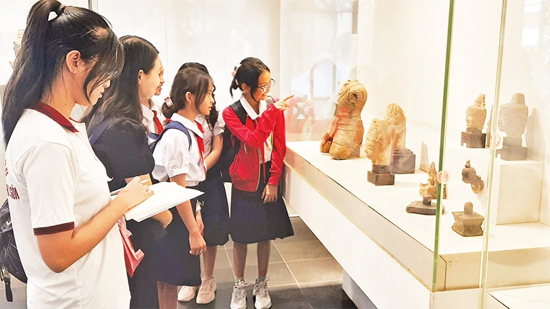 Thí sinh tham gia cuộc thi "Lớn lên cùng sách" tìm hiểu thông tin tại Bảo tàng lịch sử Thành phố Hồ Chí Minh. 