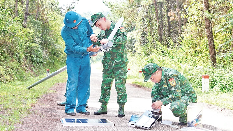 Cán bộ, chiến sĩ Ðồn Biên phòng Chi Lăng lắp đặt đèn năng lượng mặt trời trên đường tuần tra biên giới. 