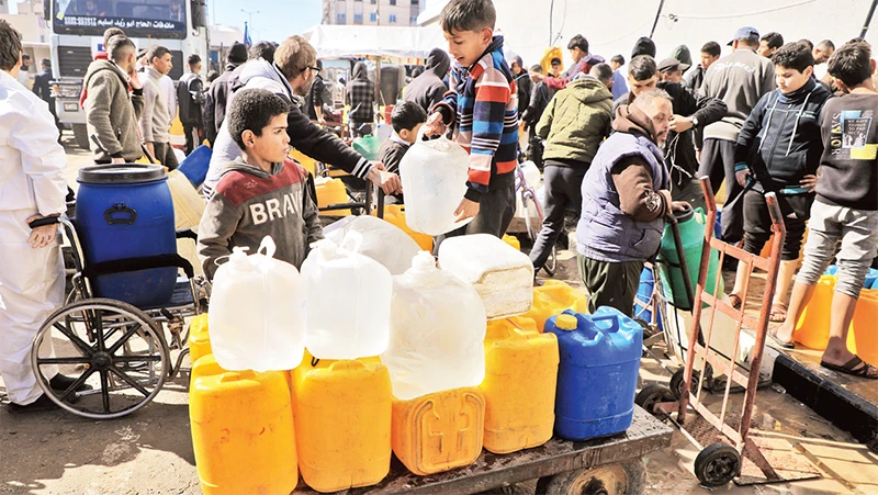 Người dân chờ lấy nước sạch ở phía nam Dải Gaza. 