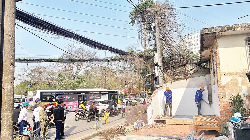 Lực lượng chức năng phường Mai Ðộng tháo dỡ các công trình để bàn giao mặt bằng cho dự án mở rộng đường Tam Trinh. 