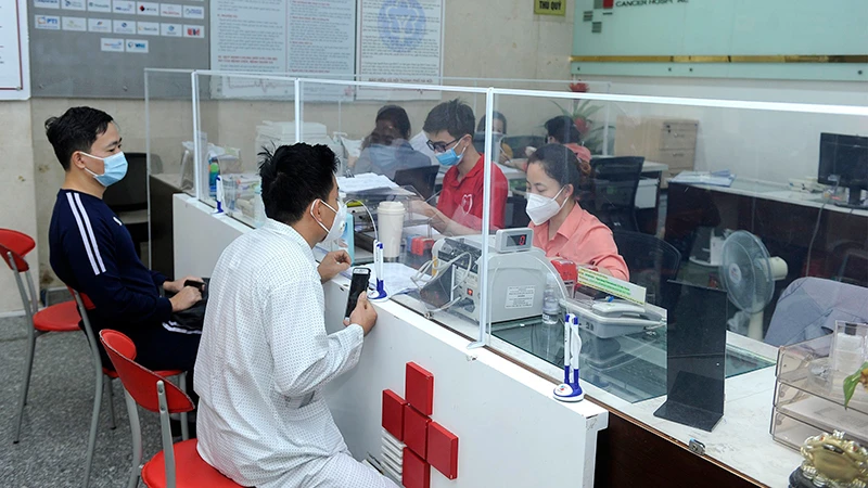 Bệnh nhân và người nhà làm thủ tục thanh toán bảo hiểm y tế tại Bệnh viện Ung bướu Hưng Việt (Hà Nội). (Ảnh NGUYỄN ÐĂNG) 