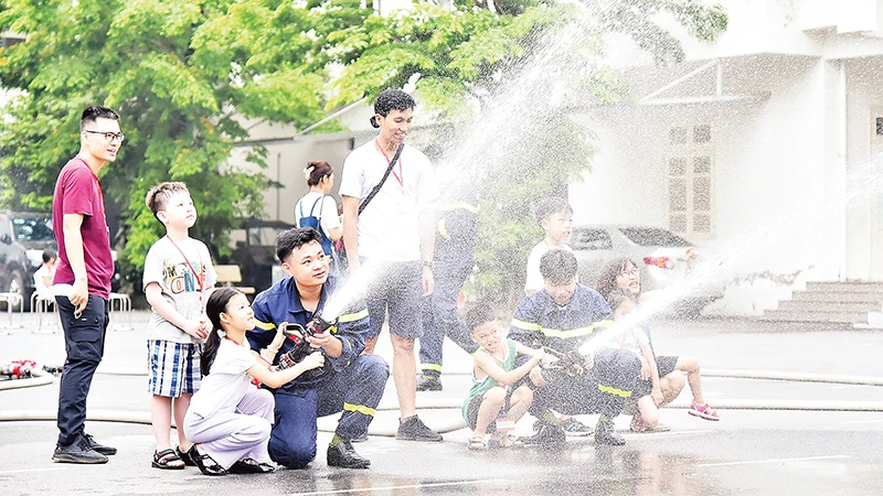 Các em học sinh tham gia thực hành cùng cán bộ, chiến sĩ Trường đại học Phòng cháy chữa cháy. (Ảnh MỸ HÀ) 