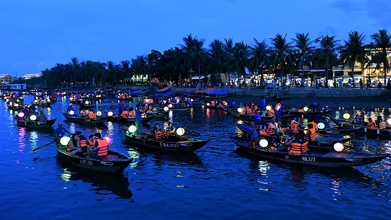 Du khách đi thuyền trên sông Hoài tham quan phố cổ Hội An vào ban đêm. (Ảnh ÐĂNG KHOA) 