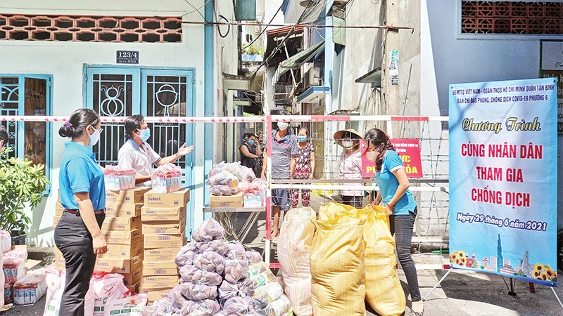 Cán bộ Mặt trận và các tổ chức thành viên trao thực phẩm hỗ trợ người dân trong giai đoạn đại dịch Covid-19 diễn biến căng thẳng tại Thành phố Hồ Chí Minh. 