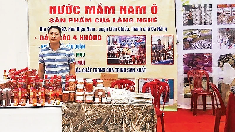 Anh Phan Vinh Quang bên gian hàng giới thiệu nước mắm Nam Ô gia truyền. 