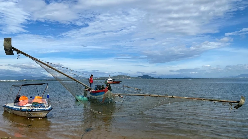 Cán bộ Đồn Biên phòng Nhơn Lý dẫn giải tàu cá ông Đinh Văn Ơi vào bờ.