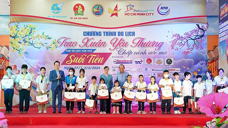 Nguyên Phó Thủ tướng Thường trực Trương Hòa Bình (bên phải, hàng thứ hai) và Chủ tịch Hội Doanh nhân trẻ Việt Nam Đặng Hồng Anh (thứ 4 từ trái sang) trao quà tặng các em nhỏ có hoàn cảnh khó khăn.