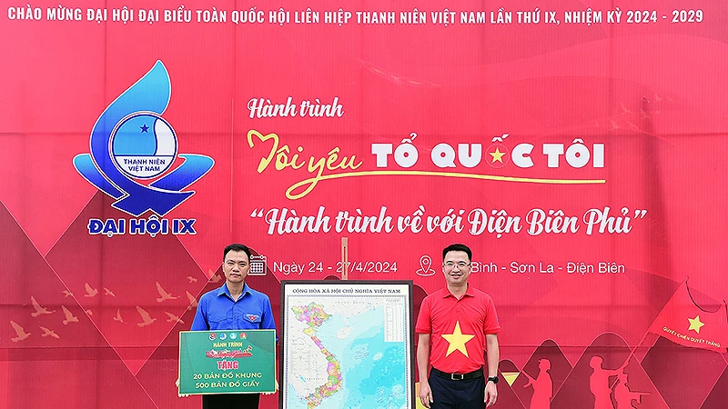 Đồng chí Nguyễn Tường Lâm (bên phải) trao bản đồ Tổ quốc tặng đại diện tuổi trẻ Hòa Bình.