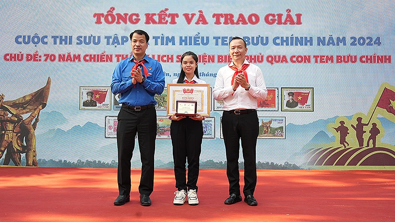 Bí thư Trung ương Đoàn Ngô Văn Cương (bên trái) và đại diện Ban tổ chức Cuộc thi trao giải đặc biệt tặng thí sinh Đặng Lê Gia Nhi.