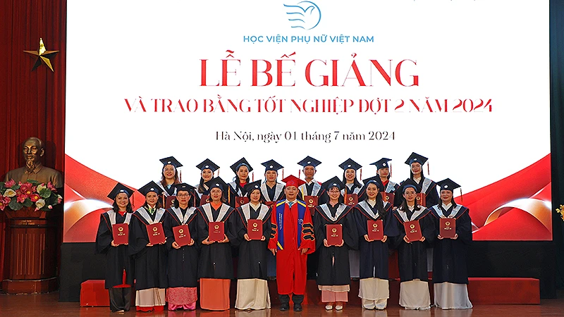 PGS.TS Trần Quang Tiến, Giám đốc Học viện Phụ nữ Việt Nam (áo đỏ) trao bằng tốt nghiệp tặng các học viên cao học khóa 3 của Học viện tại buổi lễ.