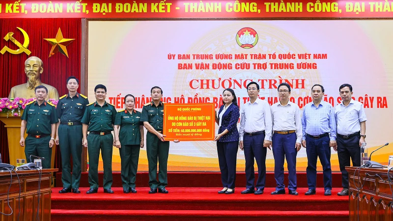 Đồng chí Nguyễn Thị Thu Hà (thứ 5 từ phải sang) tiếp nhận ủng hộ từ đoàn đại biểu Bộ Quốc phòng. 