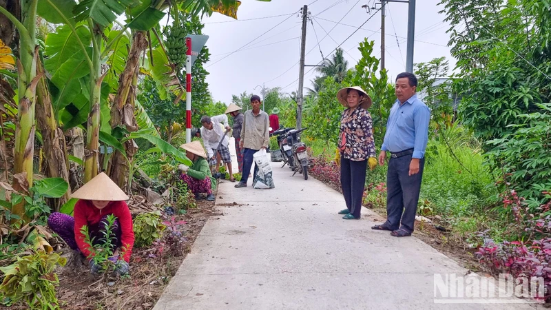 Những cô chú ấp Mỹ Phú tham gia trồng hoa trên tuyến đường giao thông nông thôn ở địa phương. 