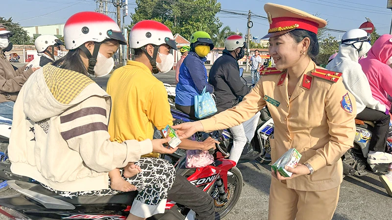 Lực lượng cảnh sát giao thông Công an tỉnh Vĩnh Long tặng nước suối và sữa cho người đi đường