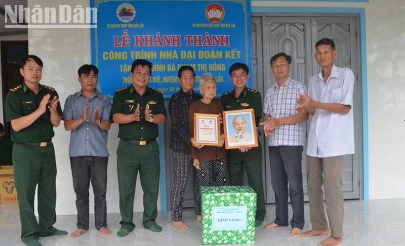 Đại diện Bộ Chỉ huy Bộ đội Biên phòng tỉnh Đắk Lắk và các đơn vị trao cờ Tổ quốc, ảnh Bác Hồ, biểu trưng và quà tặng gia đình bà Phạm Thị Hồng.