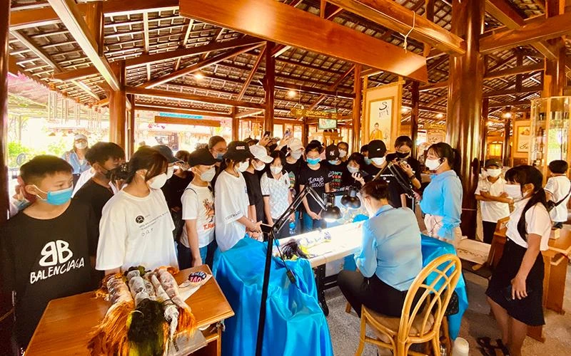 Du khách chiêm ngưỡng nét hào hoa của nghề thêu truyền thống tại làng nghề Trường Sơn (Nha Trang, Khánh Hòa).