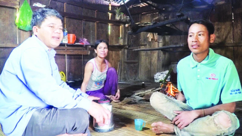 Bí thư chi bộ thôn 2, Hồ Văn Đuôi (trái) vận động người dân thực hiện các nghị quyết của chi bộ.