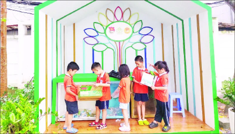 Các em học sinh thực hiện phân loại rác tái chế.