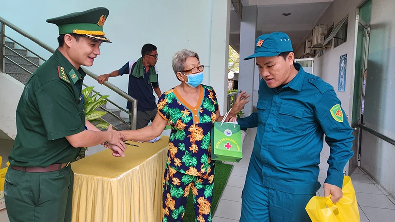 Bộ đội Biên phòng, dân quân hỗ trợ người dân đến khám bệnh, cấp phát thuốc miễn phí và nhận quà Tết tại thành phố Hà Tiên, tỉnh Kiên Giang. 