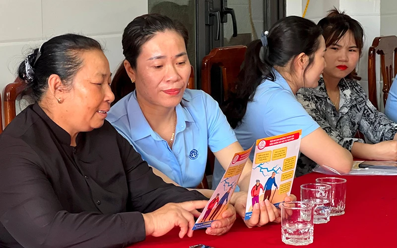 Cán bộ Bảo hiểm xã hội thị xã Ba Đồn (tỉnh Quảng Bình) tuyên truyền chính sách bảo hiểm xã hội tự nguyện cho người dân.