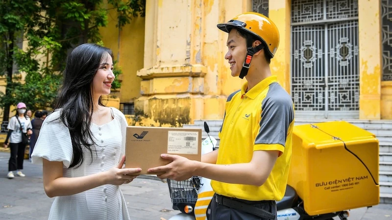 Nhân viên bưu điện phát bưu gửi đến tay khách hàng
