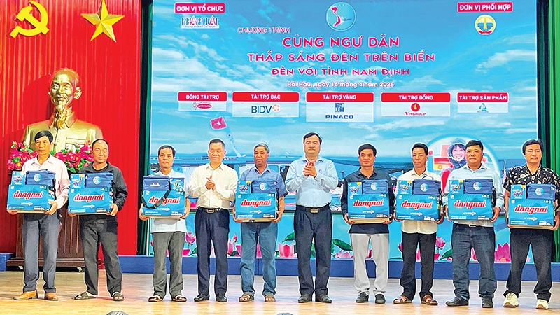 Lãnh đạo tỉnh Nam Định cùng nhà tài trợ trao bình ắc-quy, đèn led, túi thuốc và cẩm nang “Những điều cần biết về đánh bắt hải sản” tặng ngư dân.