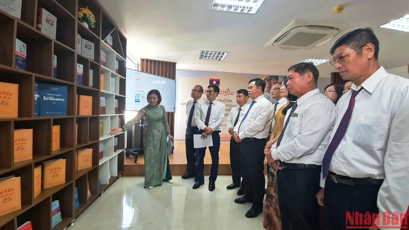 Các đại biểu tham dự Triển lãm nghe giới thiệu sách về mối quan hệ hữu nghị truyền thống đặc biệt giữa hai nước Việt Nam và Lào. 