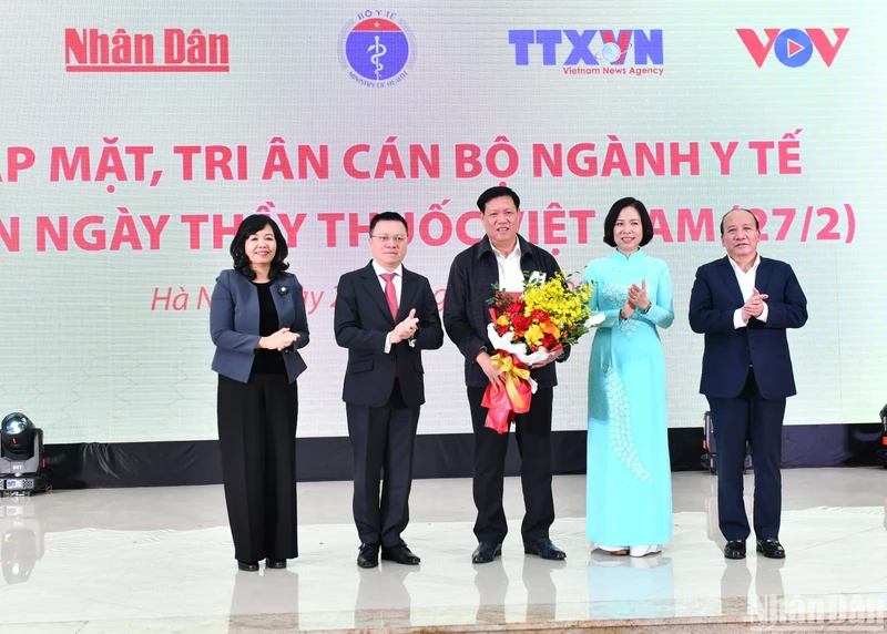 Tổng Biên tập Báo Nhân Dân Lê Quốc Minh và lãnh đạo các cơ quan báo chí chủ lực tặng hoa cho Thứ trưởng Thường trực Bộ Y tế Đỗ Xuân Tuyên nhân Ngày Thầy thuốc Việt Nam. (Ảnh: ĐĂNG KHOA)