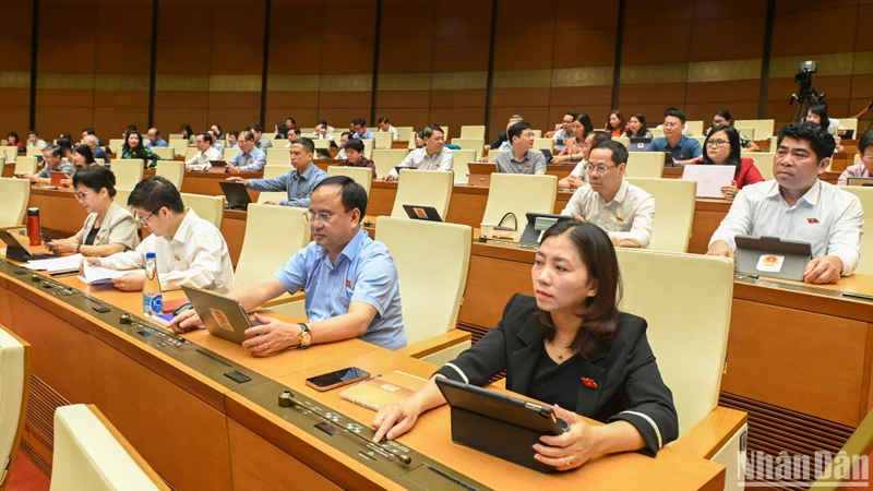 Các đại biểu Quốc hội bấm nút thông qua việc điều chỉnh Chương trình Kỳ họp thứ 9, Quốc hội khóa XV. (Ảnh: BÙI GIANG)