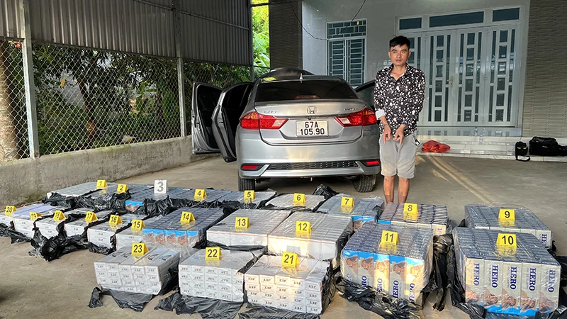 Đối tượng Huỳnh Văn Bổn cùng tang vật thuốc lá nhập lậu.