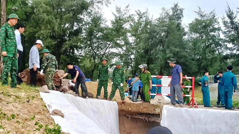 Các cán bộ, chiến sĩ Biên phòng cùng lực lượng địa phương khắc phục sự cố sạt lở kè biển do mưa lũ ở xã Phú Diên (huyện Phú Vang). 